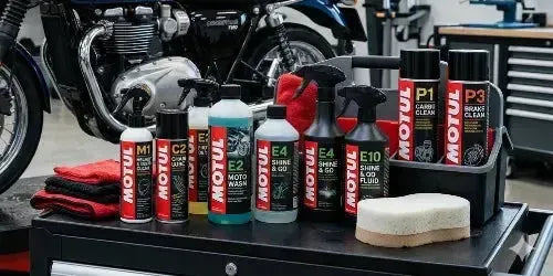 Motul motorcykelplejeprodukter: rengøringsmidler, shine & go, svamp og klude for vedligeholdelse.